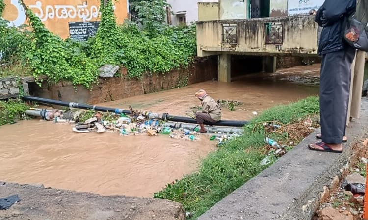 ಪ.ಪಂ ಅಧಿಕಾರಿಗಳ ವೈಫಲ್ಯ ; ಹರಿಯುತ್ತಿರುವ ನೀರಿನಲ್ಲೇ ಪೌರಕಾರ್ಮಿಕನಿಂದ ಕಸ ವಿಲೇವಾರಿ